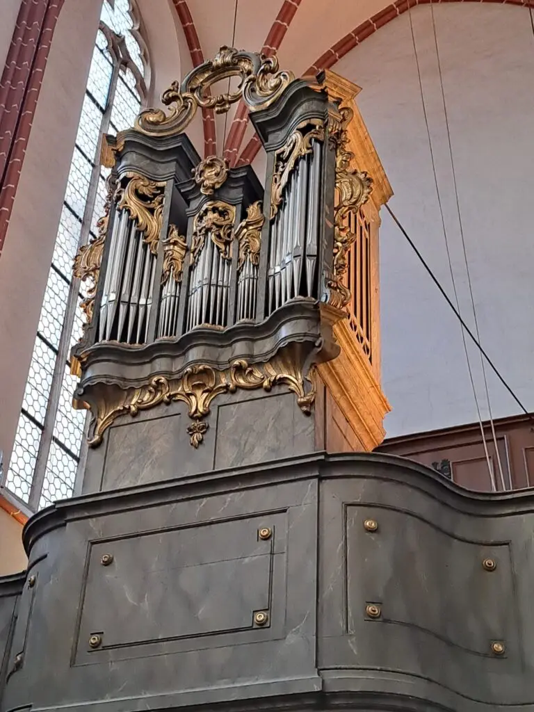 Orgel im Stil des 18. Jahrhunderts, die Orgel steht auf der Empore, man sieht die Orgelpfeifen und die reichhaltige Verzierung