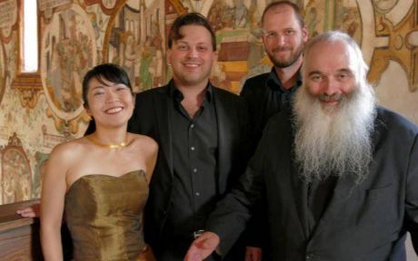 Prof. Stolz und sein Ensemble Cappella splendor solis lachend vor einer bemalten Wand